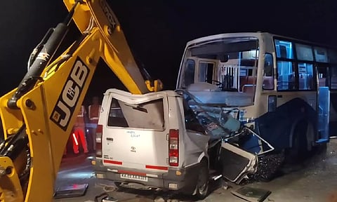 An earthmover separating and removing the car and the bus that were involved in the accident near Chengam