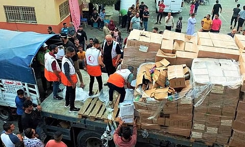 Members of the Palestine Red Crescent Society distribute aid to people in Deir al-Balah, in the central Gaza Strip (Photo: Reuters)