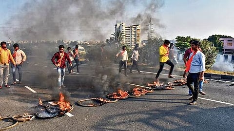 Members of Maratha Kranti Morcha burn tyres and other inflamable items on Pune-Solapur Highway, on Tuesday. (PTI)