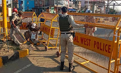 Police personnel stand guard in a violence-hit area of Imphal town. (PTI)