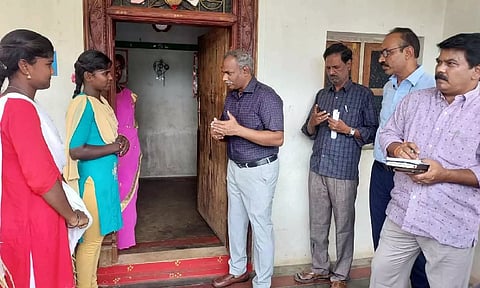 Collector D Baskara Pandian convincing a student to return to school in Natrampalli on Tuesday