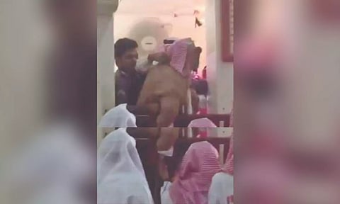 A man being forcibly removed from the dais at a mosque (Screengrab)