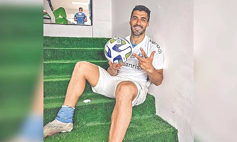 Luis Suarez poses with the match ball after scoring a hat-trick for his club Gremio