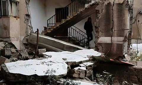 A Palestinian man walks in a damaged building after Israeli forces raided Jenin refugee camp in the Israeli-occupied West Ban (Reuters)