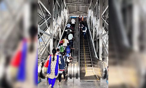 Commuters climbing up and down a non-working escalator at a station