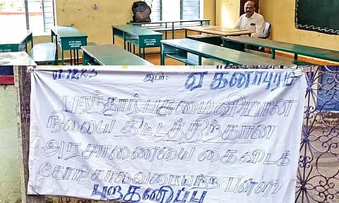 A teacher sits in an empty classroom in the Eganapuram panchayat middle school; a notice displayed outside the school about the protest by villagers