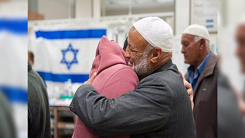 Freed captive Bilal Ziyadne (left) reunites with his family on November 30 (Photo/TPS)