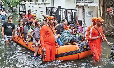 Emergency services personnel rescue stranded residents from a flooded colony in city Wednesday