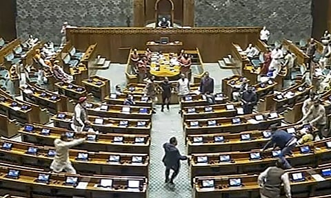 A visitor jumps into the Lok Sabha chamber from the public gallery on December 13, 2023. (Sansad TV/PTI)
