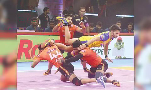 Thalaivas raider Narender is tackled by U Mumba defenders. 