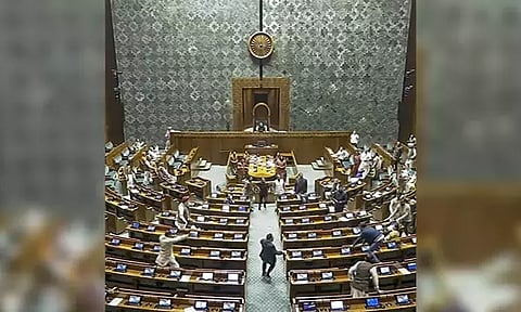 A visitor jumps into the Lok Sabha chamber from the public gallery on December 13. (Sansad TV/PTI)