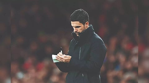 Mikel Arteta takes notes during Arsenal vs West Ham earlier this week