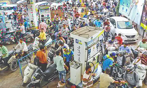 People queue up at a petrol pump during the truckers’ protest