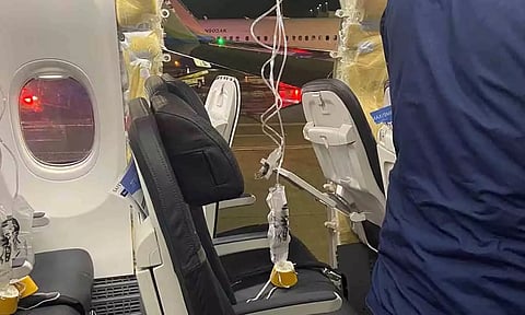  Passenger oxygen masks hang from the roof next to a missing window of an Alaska Airlines Flight 1282 (Reuters)