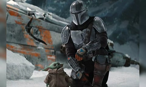 This image released by Disney+ shows Pedro Pascal in a scene from “The Mandalorian.” Jon Favreau is set to direct the film “The Mandalorian & Grogu” which will go into production this year, Lucasfilm and Disney announced Tuesday. (Disney)