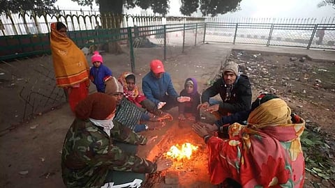 People sit around a bonfire amid fog on a cold winter morning (PTI)