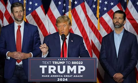 Republican presidential candidate and former U.S. President Donald Trump is flanked by his sons Donald Trump Jr. and Eric Trump as he speaks during his caucus night watch party in Des Moines (Reuters)
