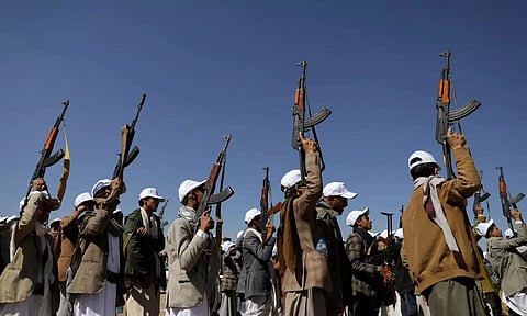 Armed Houthi followers hold up rifles as they take part in a parade during a protest to decry the U.S