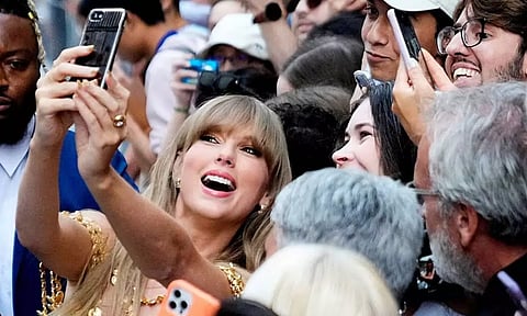 Singer Taylor Swift poses for a selfie with fans. (Reuters)