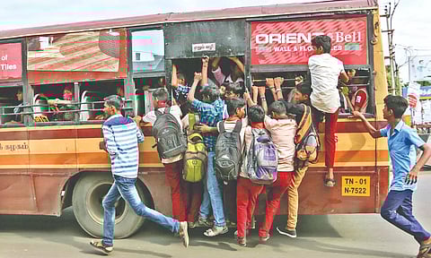 File photo of youngsters footboarding on an MTC bus
