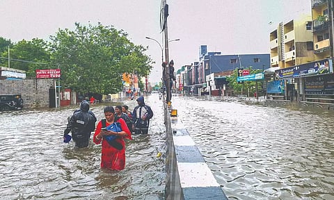 People wading through a flooded road in the city (file)