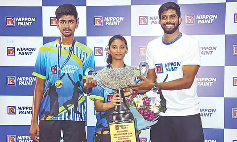 Satwiksairaj Rankireddy presents the championship trophy to Aadhavan and Laya