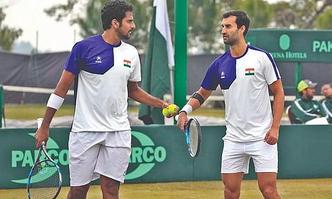 Saketh Myneni (L) and Yuki Bhambri react after bagging a point against Pakistan’s Aqeel Khan and Muzammil Murtaza