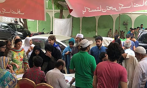Voters queue up at a PTI bench near the voting centre (X/@PTIofficial)