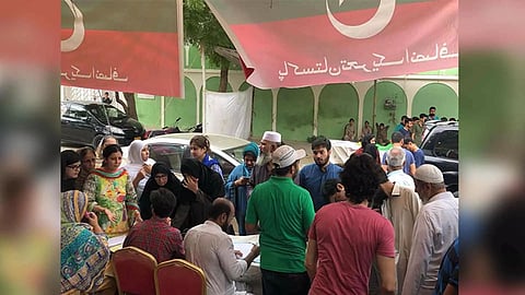 Voters queue up at a PTI bench near the voting centre (X/@PTIofficial)