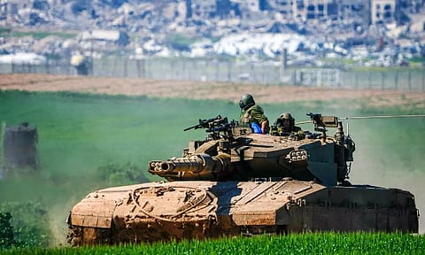 Israeli soldiers drive a tank on the border with the Gaza Strip, as seen in southern Israel