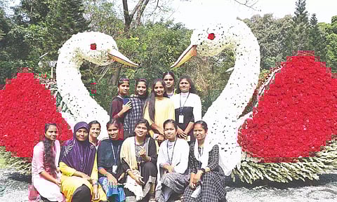 Young visitors posing for a photo in front of a model