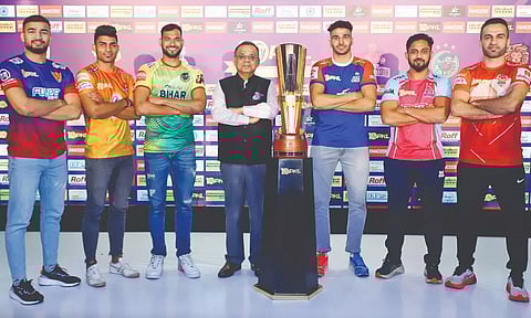 The six captains of the teams that qualified for the Playoffs pose with the PKL trophy along with the League Commissioner Anupam Goswami