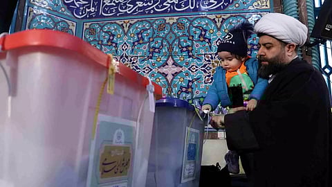 An Iranian cleric casts his vote during parliamentary elections at a polling station in Tehran, Iran (Photo/Reuters)