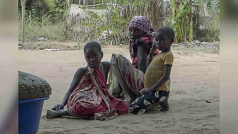 A woman with children watch as Rwandan soldiers patrol in the village of Mute, Cabo Delgado province, Mosambique (AP)