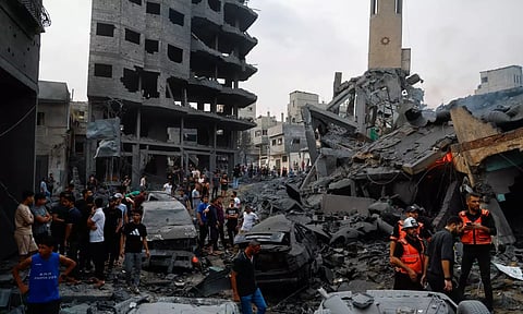 Emergency personnel and Palestinians inspect damages in the aftermath of Israeli strikes. Reuters