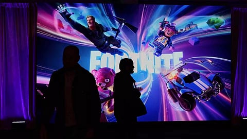 People in silhouette walk by a Fortnite gaming digital monitor during an event in New York City, U.S. (Reuters)