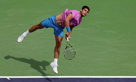Carlos Alcaraz serves against Felix Auger-Aliassime