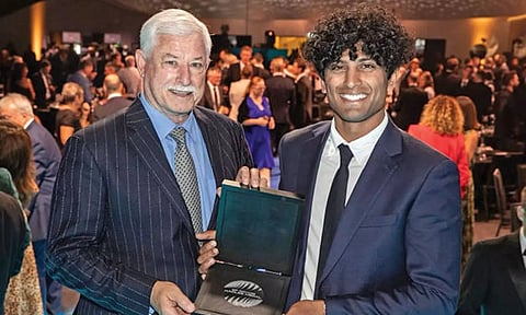 Sir Richard Hadlee and Rachin Ravindra pose with the award