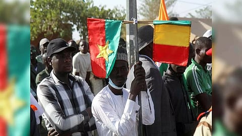 A man holds Mali and Burkina Faso flags while attending a sit-in in Niamey (Photo:Reuters)