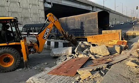 Bulldozer demolishing barricade at Ghazipur border