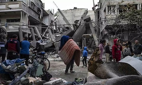 Palestinians inspect the damage of residential buildings after an Israeli airstrike in Rafah (AP)