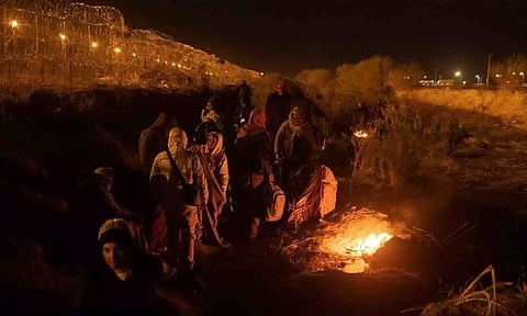 Migrants from South and Central America huddle near fire as they search for an entry point into the United States (Reuters)