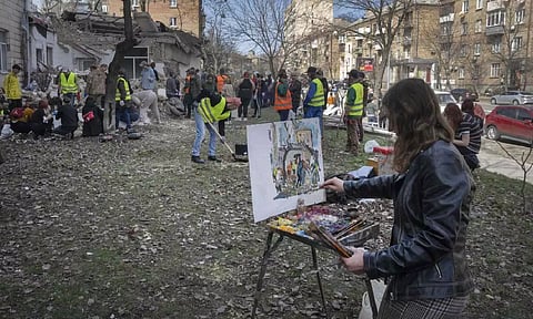 Students and volunteers clear the rubble after the Academy was partly ruined during the Russian missile (AP)