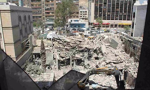 An excavator clears rubble after a suspected Israeli strike on Monday on Iran's consulate (Reuters)
