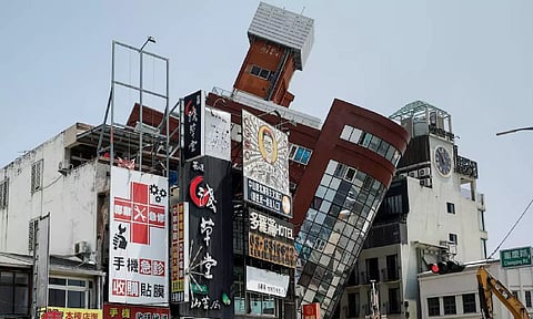A general view as workers carry out operations at the site where a building collapsed, following the earthquake, in Hualien (PTI)