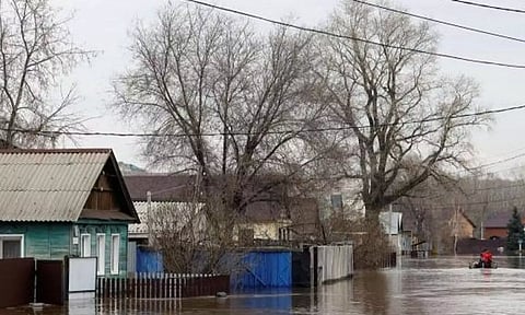 People move past in an inflatable boat in a flooded residential area in the city of Orenburg, Russia (Reuters) 