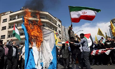 Iranians burn an Israeli flag during a rally marking Quds Day and the funeral of members of the Islamic Revolutionary Guard Corps who were killed in a suspected Israeli airstrike (Reuters) 