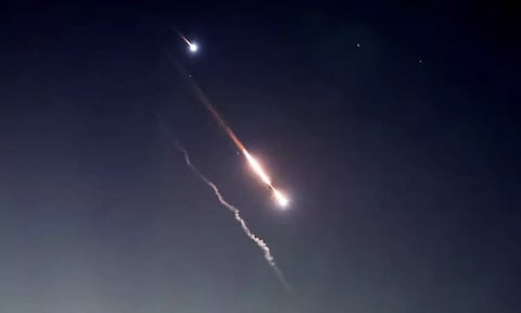 Objects are seen in the sky above Jerusalem after Iran launched drones and missiles towards Israel
