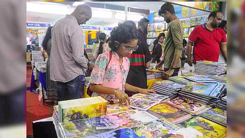 A kid flipping through comic book at the Chennai Book Fair