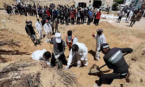 People work to move into a cemetery bodies of Palestinians killed during Israel's military offensive (Reuters)